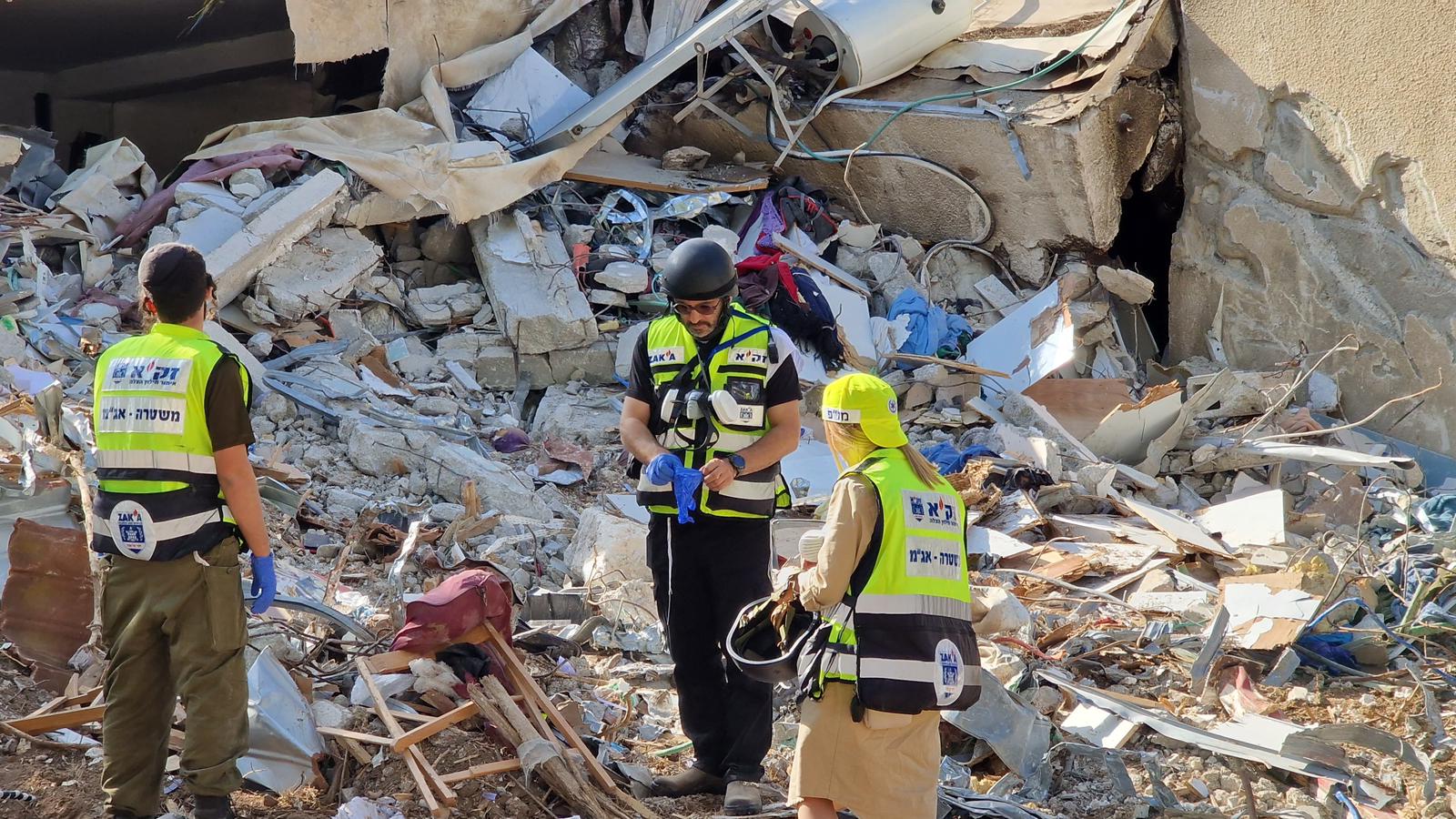 zaka volunteers on destroyed house remains