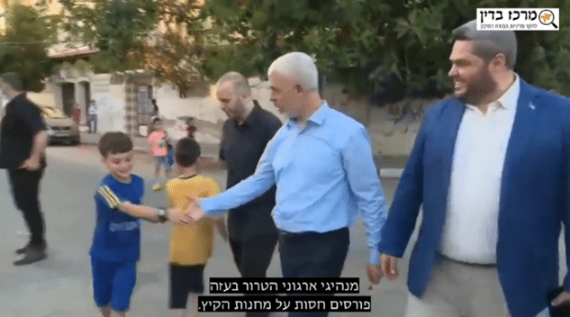 יחיא סינוואר לוחץ ידיים לילדים וכתוביות 'מנהיגי ארגוני הטרור בעזה פורסים חסות על מחנות הקיץ'