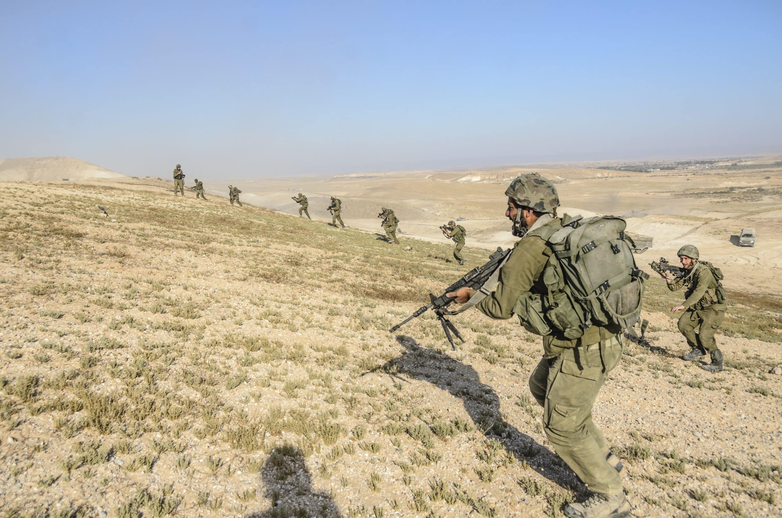 Soldiers in training storm a hill