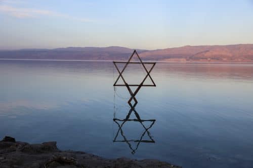 פסל מגן דוד עומד בים ומשתקף במים