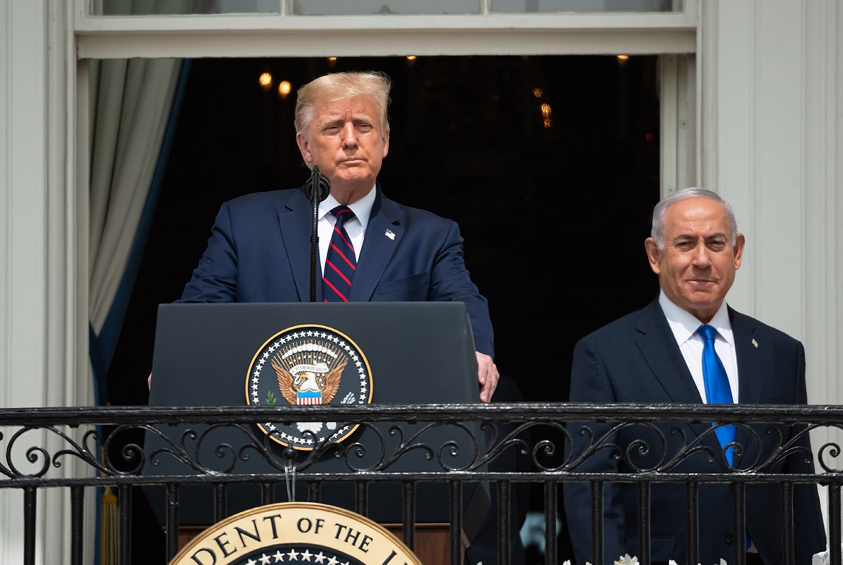 טראמפ נואם בפודיום ומאחוריו נתניהו